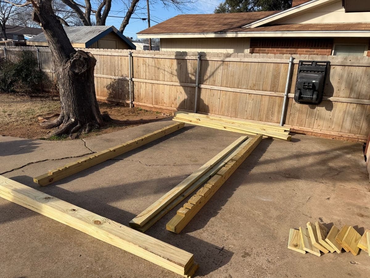 Lumber laid out on ground for shed floor frame